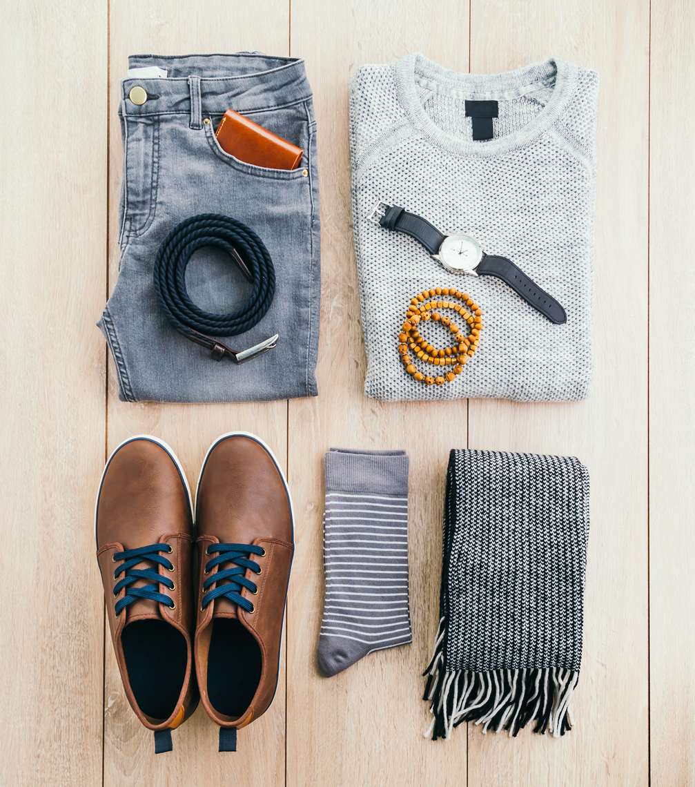 Beautiful men fashion with Sweater Jeans Belt Socks Wallet Watch and Brown leather shoes on wooden background - Vintage light filter Processing