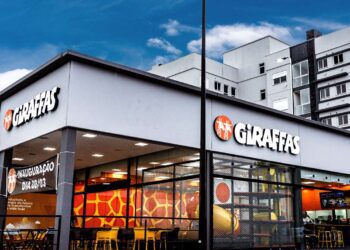 Com uma média diária de 72 mil atendimentos e mais de 26 milhões de pedidos realizados ao longo de 2024, o Giraffas lançou uma nova edição do estudo Raio X dos Hábitos Alimentares dos Consumidores. A análise mostra que o ticket médio também evoluiu no período, alcançando R$ 47,71, o que representa um aumento de 5% em relação a 2023. No ano, o frango foi a proteína mais consumida, representando 50,01% dos pedidos com proteína animal, seguido pela carne vermelha, com 48,21%. Porém, o levantamento por estado revela outro cenário: a carne vermelha liderou o consumo em 16 estados, enquanto o frango foi mais pedido em nove estados e no Distrito Federal. O estudo também aponta alguns padrões regionais: A região Sul é onde mais se compartilham refeições, apesar do crescimento dos pedidos individuais. O consumo de brindes avulsos e combos infantis se destacou no Centro-Oeste (31,96%) e no Sudeste (30,64%). Datas comemorativas como Dia das Crianças, Natal e Black Friday impulsionaram o fluxo nas lojas, com alta de até 55% em relação a fins de semana anteriores. O Nordeste teve o maior ticket médio (R$ 48,40), seguido pelo Sudeste (R$ 48,32). Já o Sul, com o menor ticket (R$ 46,88), registrou aumento nas vendas de bebidas, acompanhamentos e pratos com adicionais como espetinhos e saladas. O Centro-Oeste se destacou no consumo de sobremesas, enquanto o Norte teve crescimento nos pedidos de adicionais e bebidas. A digitalização também avançou: os totens de autoatendimento já representam mais de 50% das vendas nas lojas. Tendência de escolhas saudáveis Entre os acompanhamentos, observa-se uma inclinação crescente por opções mais leves. O arroz integral teve boa aceitação, com destaque para São Paulo (34,05% dos pedidos), além do Distrito Federal, Paraná, Goiás e Santa Catarina. Os adicionais de salada também mostraram crescimento proporcional por mil clientes. Nas bebidas, o refrigerante segue líder (71% dos pedidos), seguido por suco (14%), água (10%), cerveja (4%) e chá (1%). A cerveja apresentou queda de 11,72% em relação a 2023, enquanto sucos e água continuam em alta.