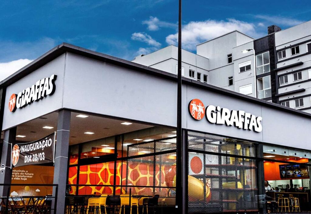 Com uma média diária de 72 mil atendimentos e mais de 26 milhões de pedidos realizados ao longo de 2024, o Giraffas lançou uma nova edição do estudo Raio X dos Hábitos Alimentares dos Consumidores. A análise mostra que o ticket médio também evoluiu no período, alcançando R$ 47,71, o que representa um aumento de 5% em relação a 2023. No ano, o frango foi a proteína mais consumida, representando 50,01% dos pedidos com proteína animal, seguido pela carne vermelha, com 48,21%. Porém, o levantamento por estado revela outro cenário: a carne vermelha liderou o consumo em 16 estados, enquanto o frango foi mais pedido em nove estados e no Distrito Federal. O estudo também aponta alguns padrões regionais: A região Sul é onde mais se compartilham refeições, apesar do crescimento dos pedidos individuais. O consumo de brindes avulsos e combos infantis se destacou no Centro-Oeste (31,96%) e no Sudeste (30,64%). Datas comemorativas como Dia das Crianças, Natal e Black Friday impulsionaram o fluxo nas lojas, com alta de até 55% em relação a fins de semana anteriores. O Nordeste teve o maior ticket médio (R$ 48,40), seguido pelo Sudeste (R$ 48,32). Já o Sul, com o menor ticket (R$ 46,88), registrou aumento nas vendas de bebidas, acompanhamentos e pratos com adicionais como espetinhos e saladas. O Centro-Oeste se destacou no consumo de sobremesas, enquanto o Norte teve crescimento nos pedidos de adicionais e bebidas. A digitalização também avançou: os totens de autoatendimento já representam mais de 50% das vendas nas lojas. Tendência de escolhas saudáveis Entre os acompanhamentos, observa-se uma inclinação crescente por opções mais leves. O arroz integral teve boa aceitação, com destaque para São Paulo (34,05% dos pedidos), além do Distrito Federal, Paraná, Goiás e Santa Catarina. Os adicionais de salada também mostraram crescimento proporcional por mil clientes. Nas bebidas, o refrigerante segue líder (71% dos pedidos), seguido por suco (14%), água (10%), cerveja (4%) e chá (1%). A cerveja apresentou queda de 11,72% em relação a 2023, enquanto sucos e água continuam em alta.